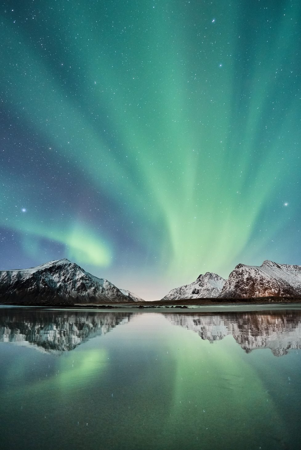 Aurora borealis in Norway overlooking mountains and lake
