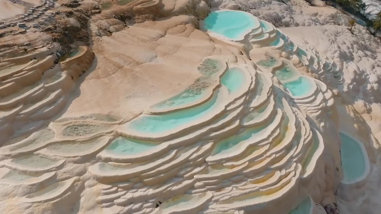 Sunlit mineral terraces and turquoise pools in Yunnan