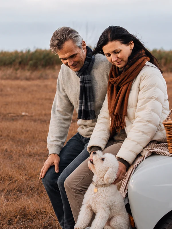 Couple sitting together outdoors with their dog