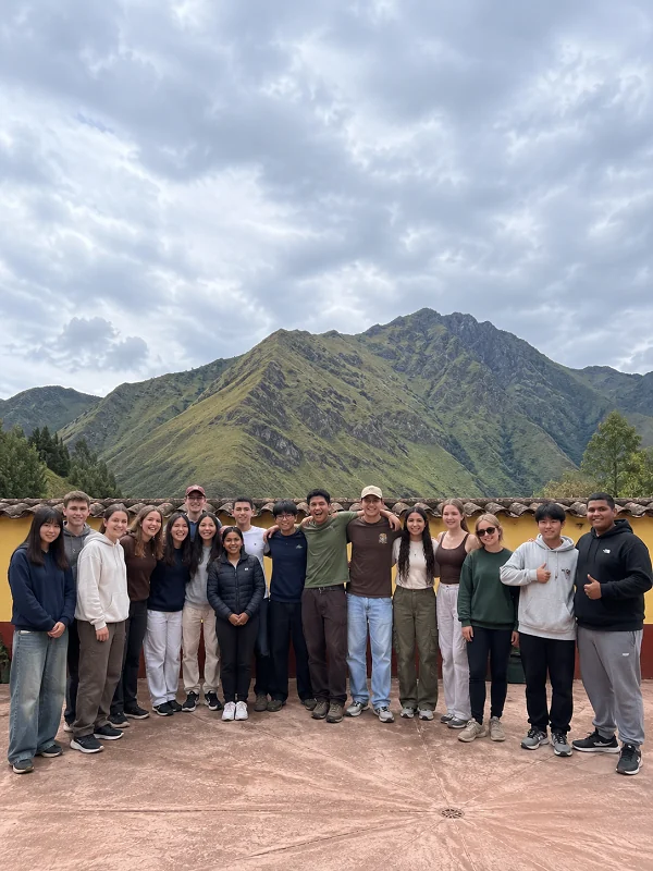 Young travel group gathered before a mountain landscape
