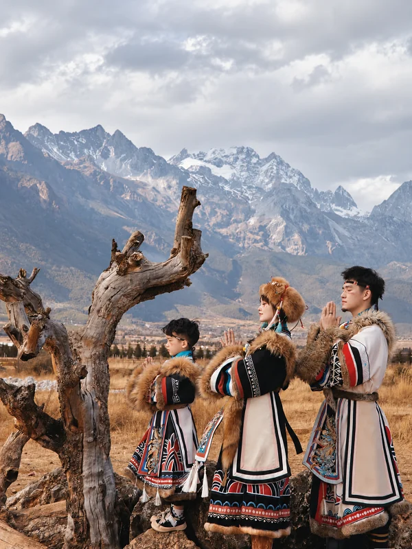 Family in traditional dress with snowy mountains behind