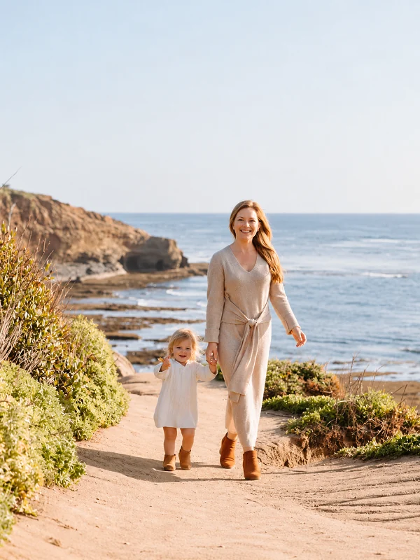 Mother and daughter walking along a coastal path