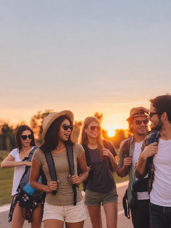 Young friends walking together at sunset