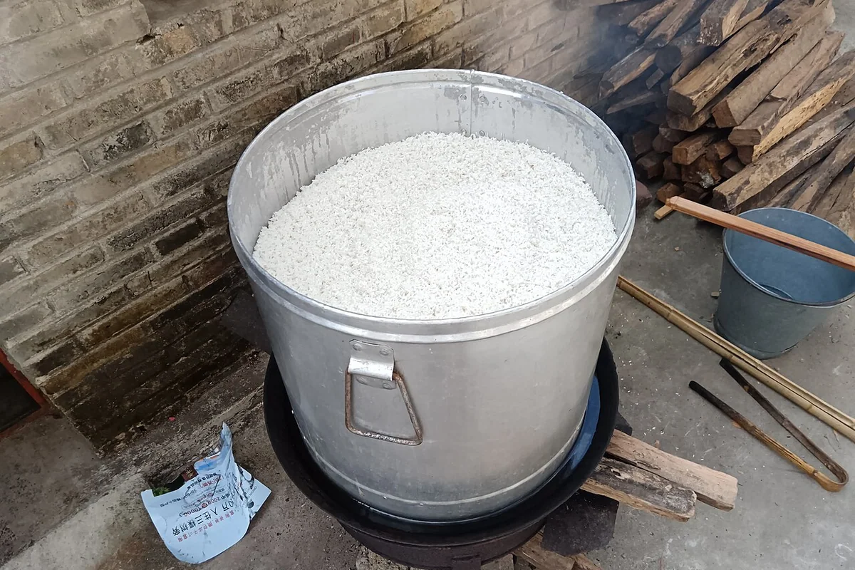Rice steaming for Jingpho sweet rice wine making, Mangshi, China.jpg